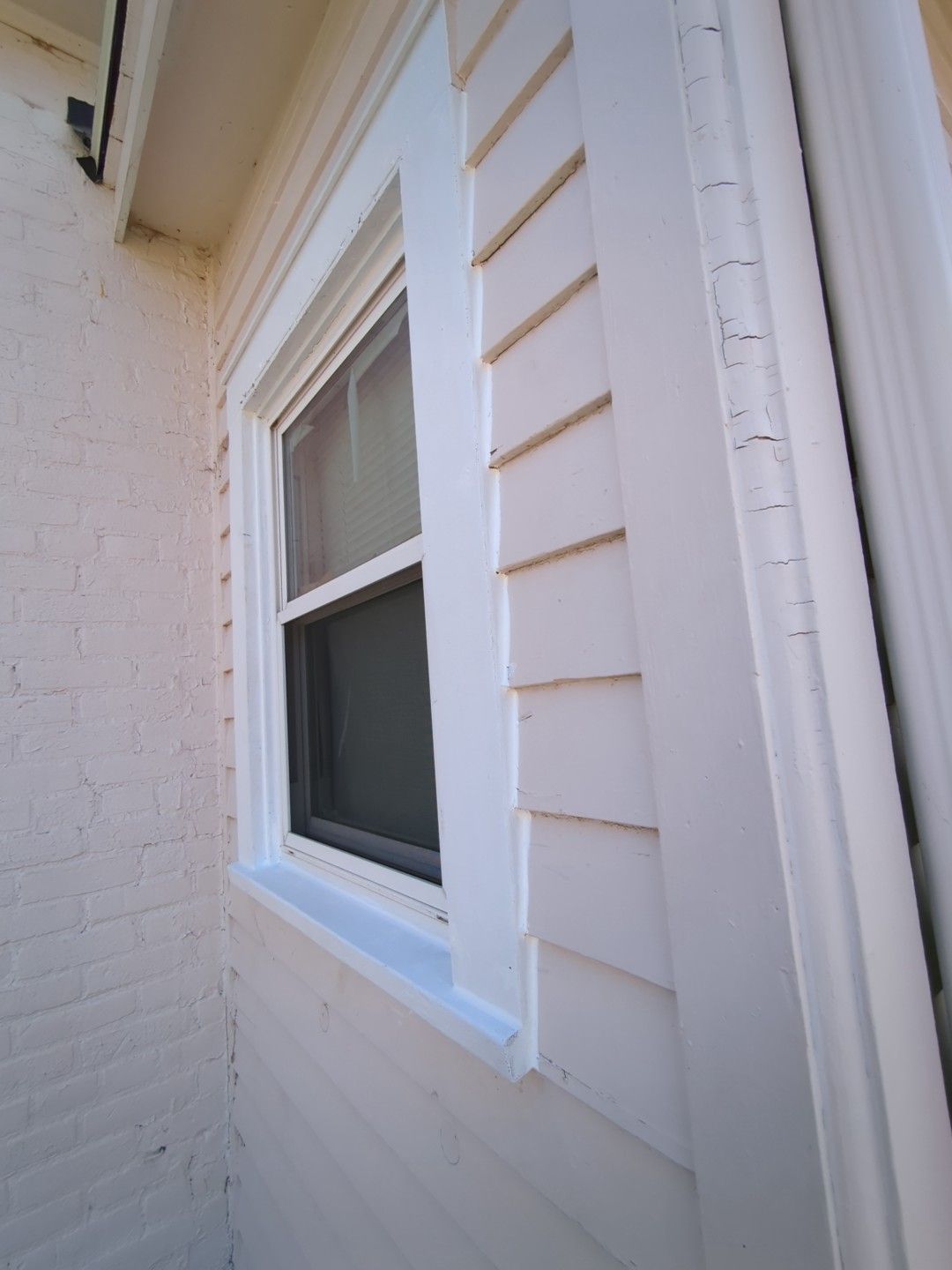 A white house with a window on the side