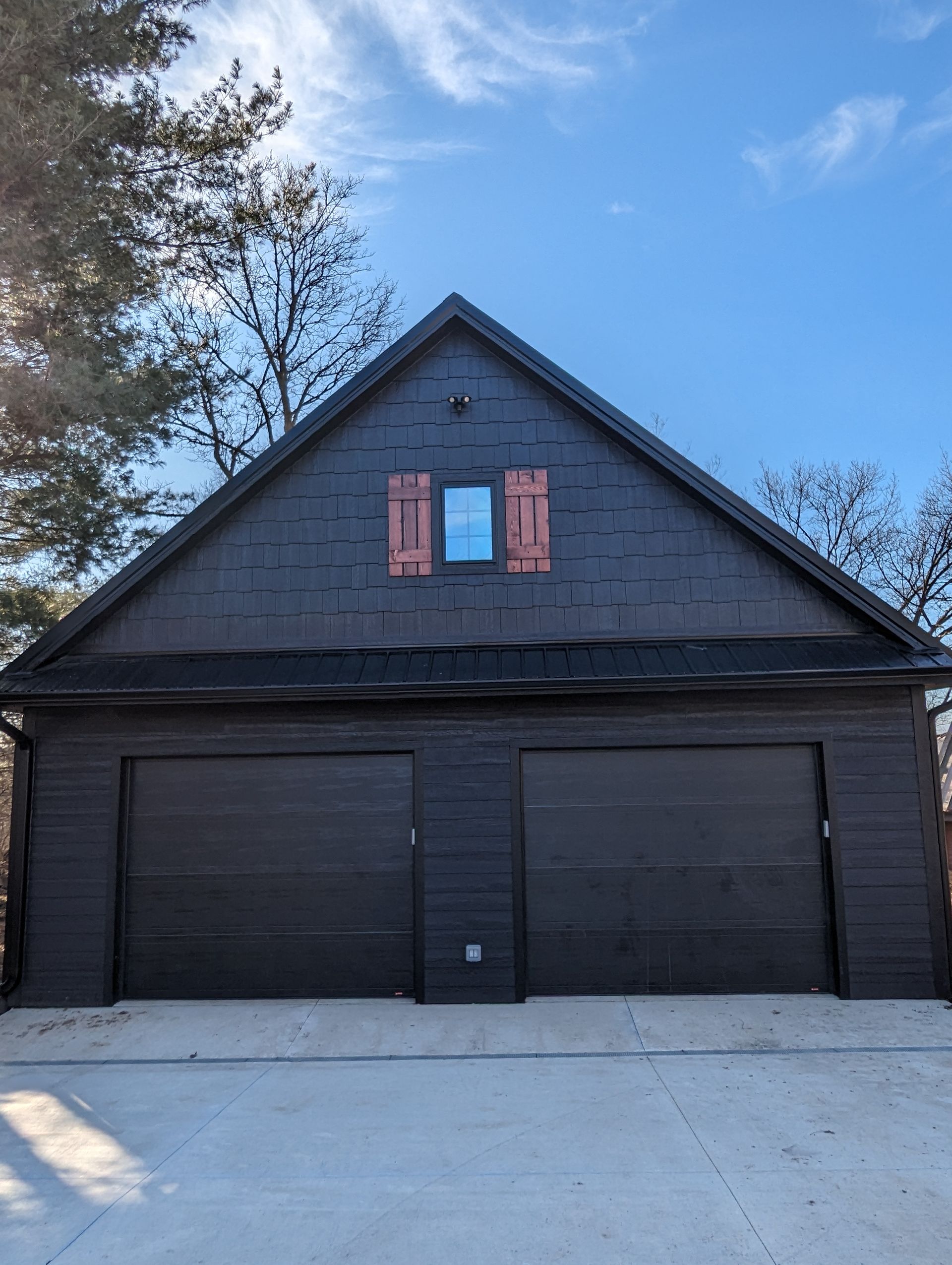A garage with two garage doors and a window on the roof