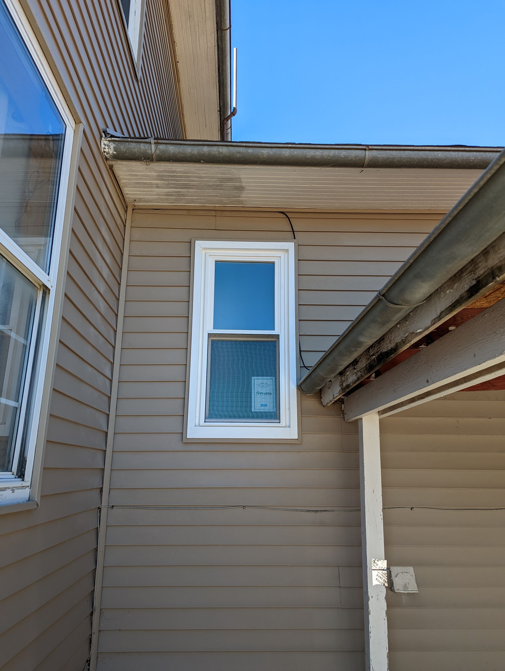 A window on the side of a house next to a garage