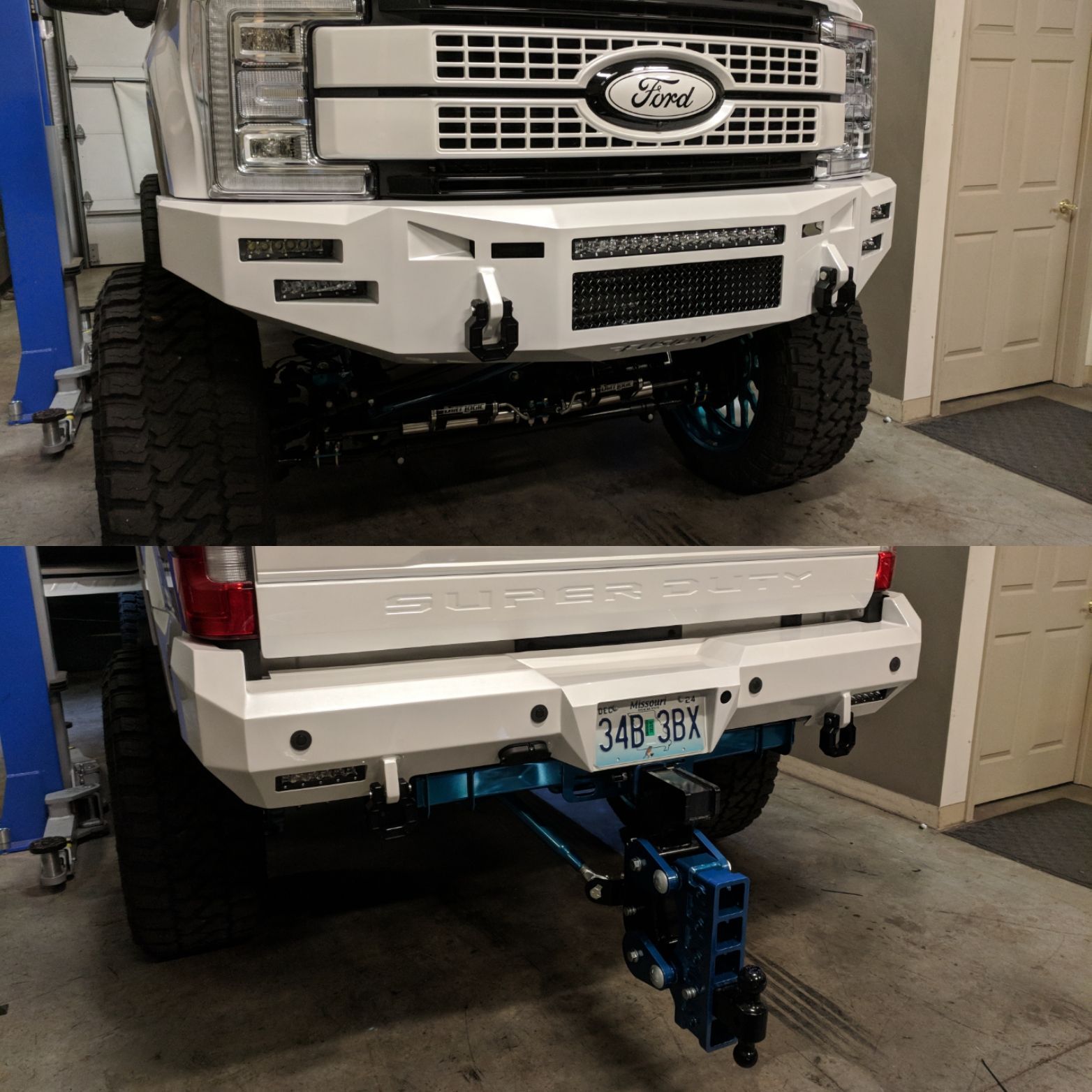 Two white Ford trucks stacked in a garage, with the lower truck on a blue hoist/jack.