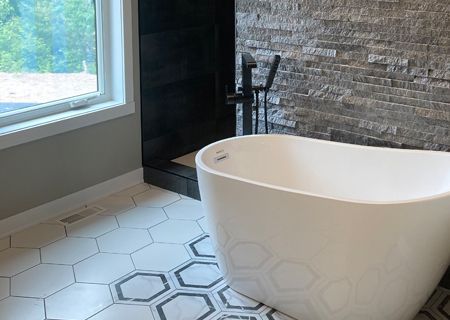 A bathtub is sitting in a bathroom next to a window.