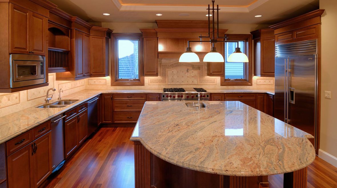 Spacious modern kitchen with wood cabinets, granite island, and stainless steel appliances