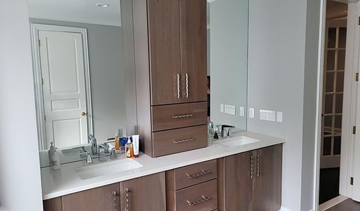 Modern kitchen with white counters, wood cabinets, and a doorway to the right