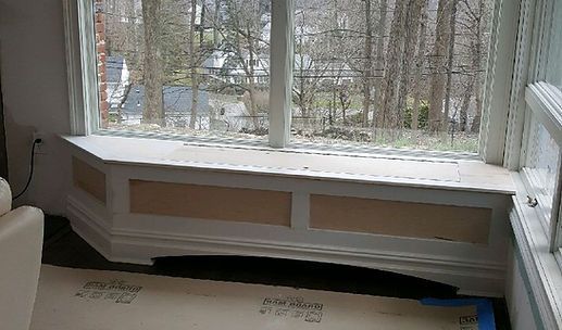 Large front window in a living room, showing snowy trees outside and a white radiator below.