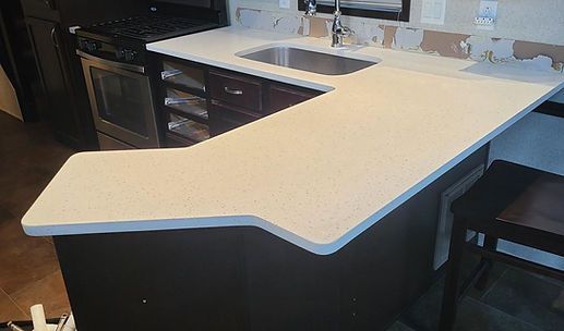 Modern kitchen with a large white island countertop and dark cabinetry
