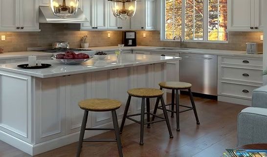 Modern white kitchen with island, stainless appliances, pendant lights, and three wooden stools