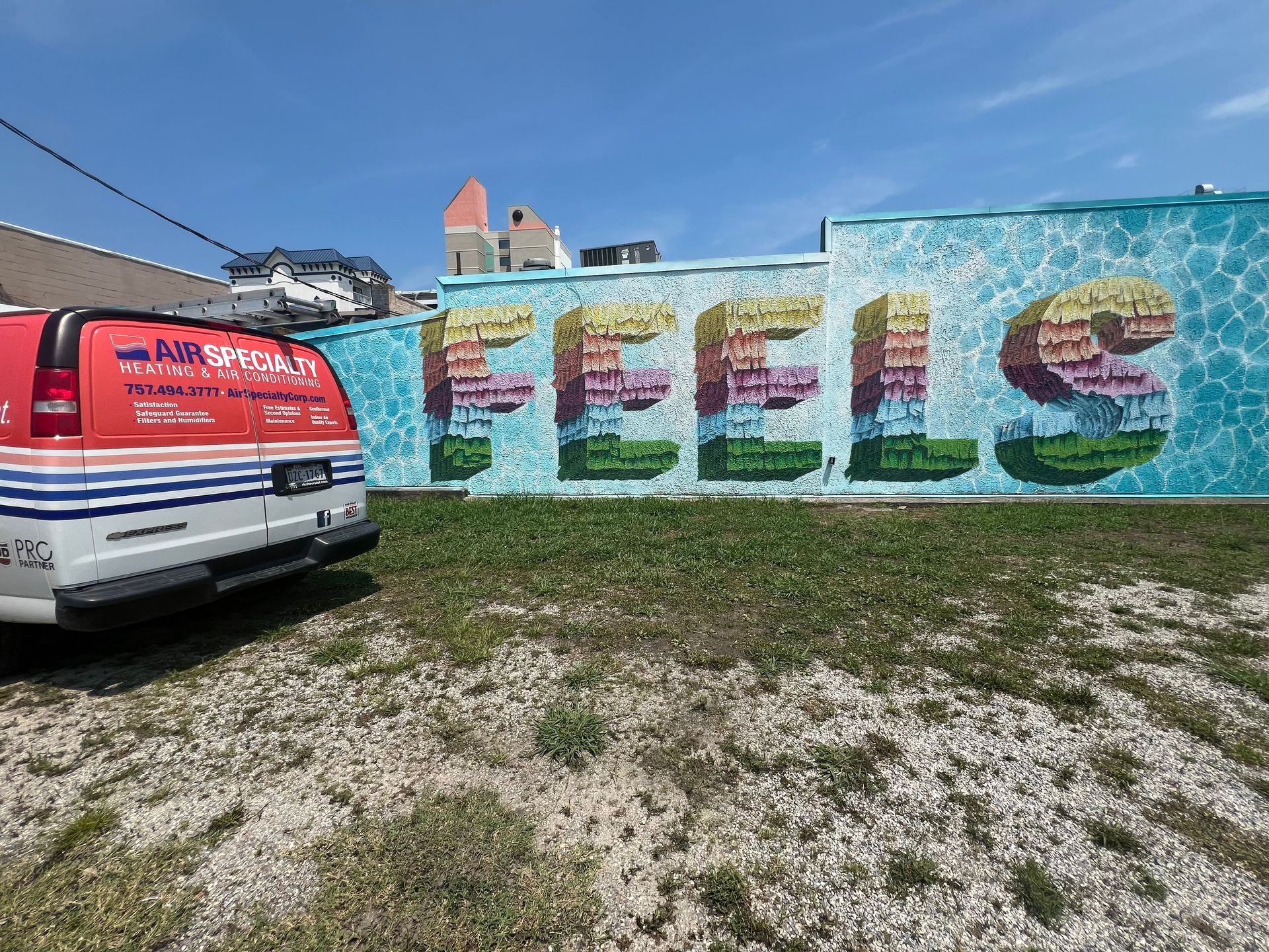 A van is parked in front of a wall with the word feels painted on it.