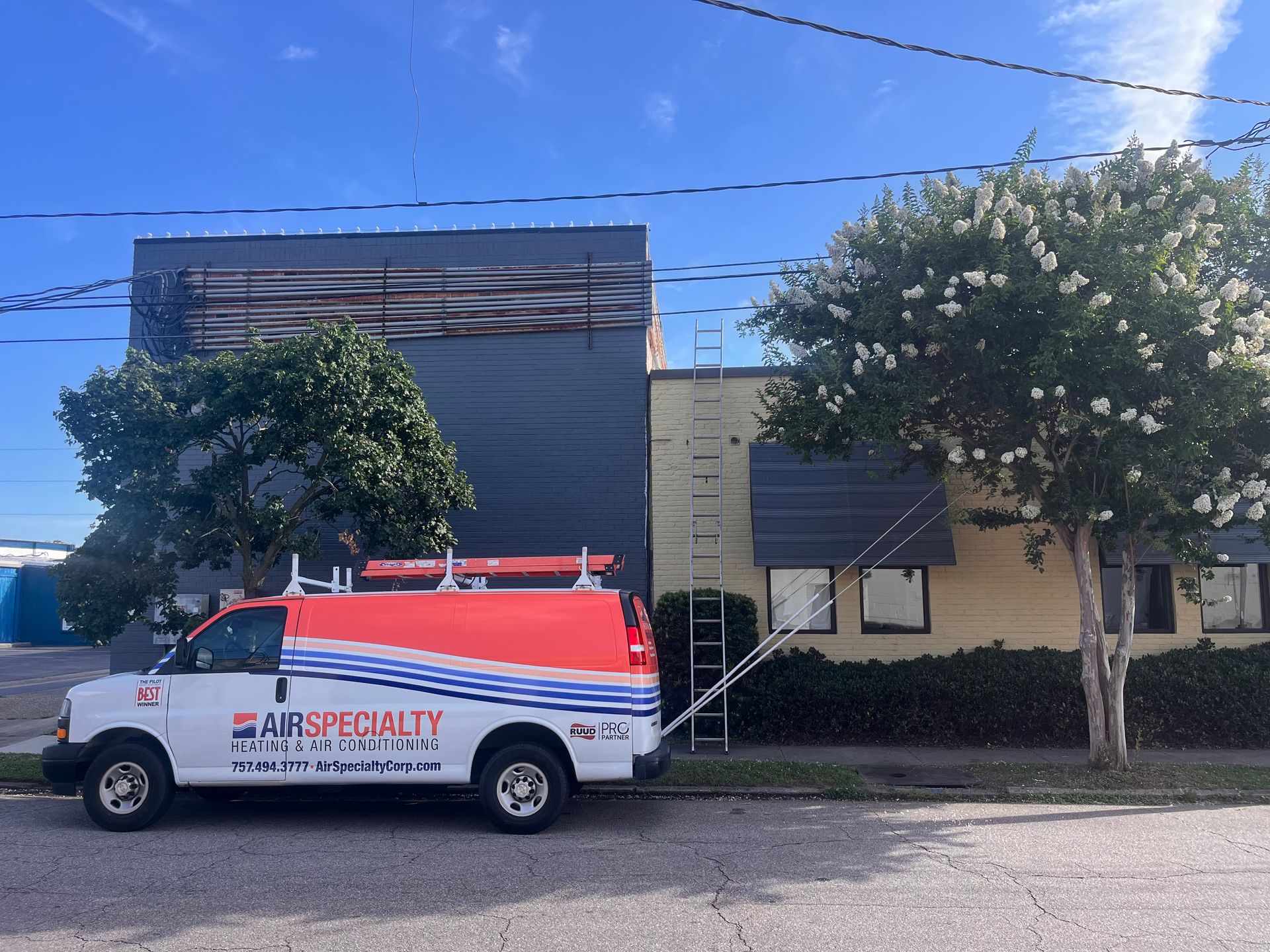 An air specialty van is parked in front of a building