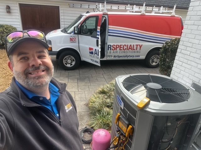 A man is standing in front of a van next to an air conditioner.