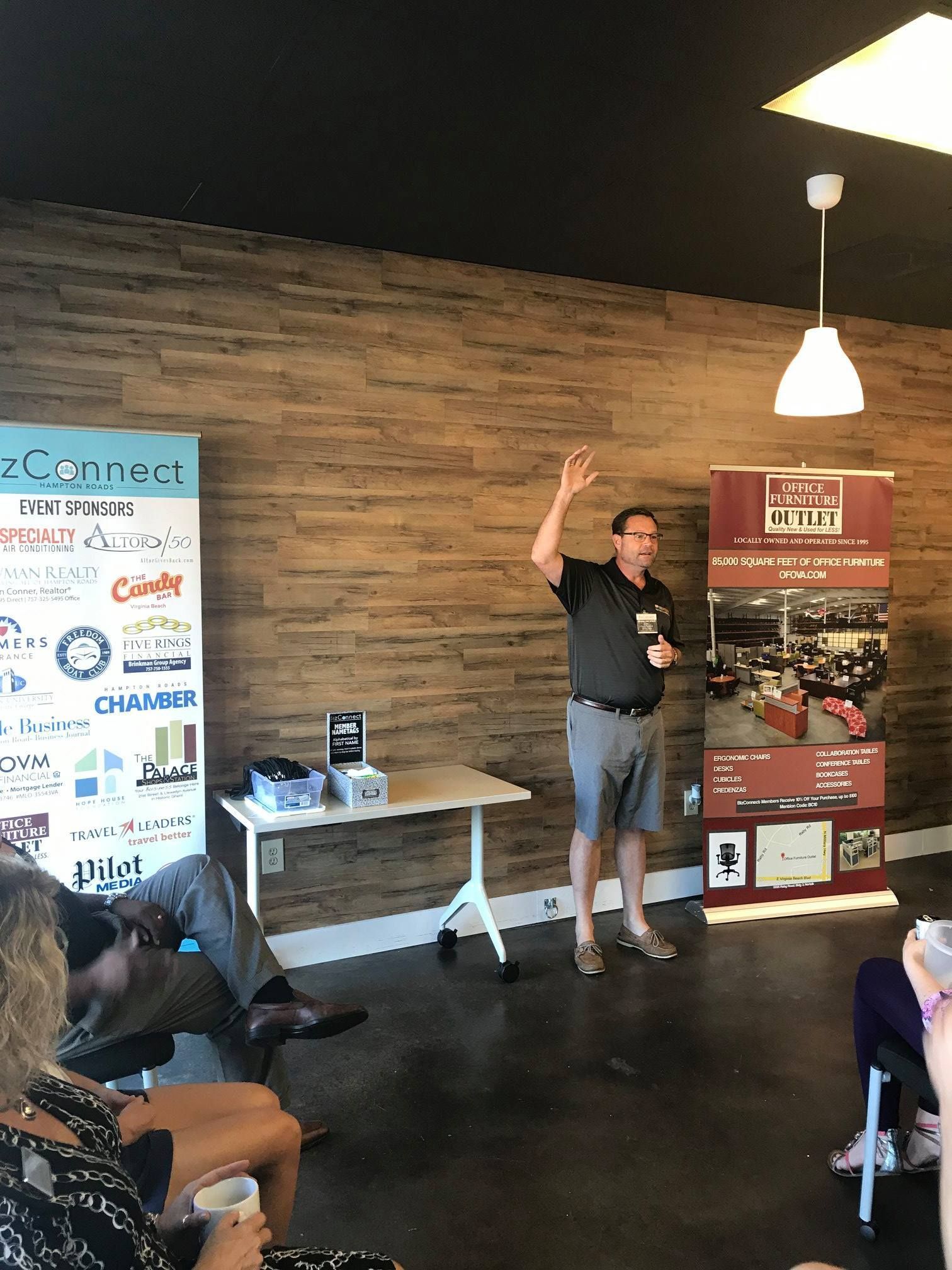 A man is giving a presentation to a group of people in a room