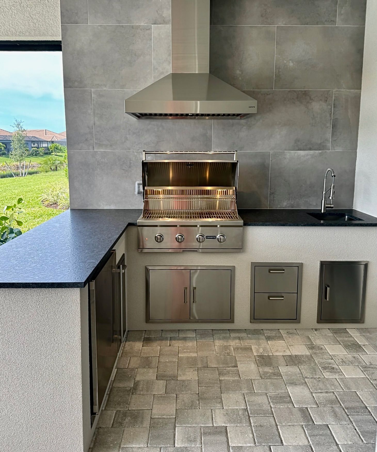 A kitchen with a grill and a hood above it.