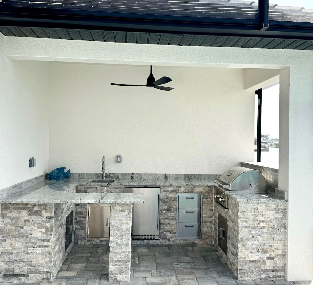 A kitchen with a sink and a ceiling fan.