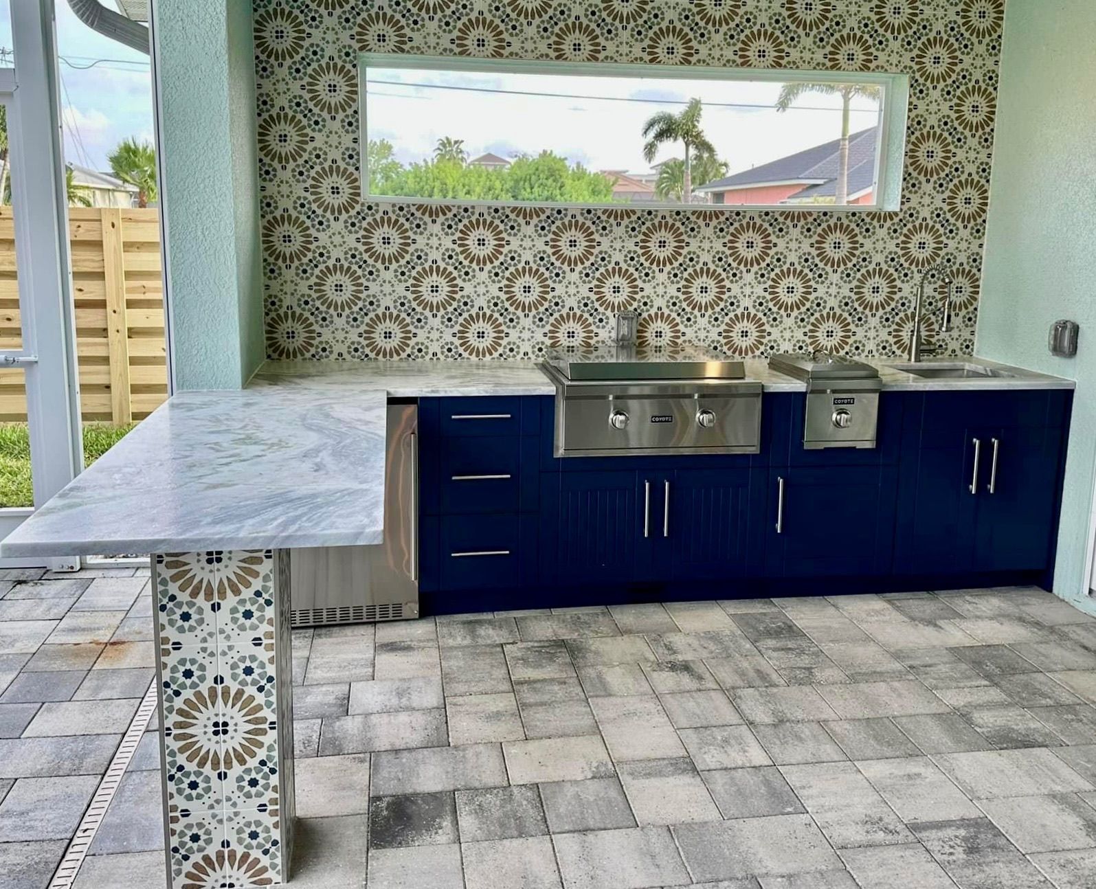 A kitchen with blue cabinets and a marble counter top.