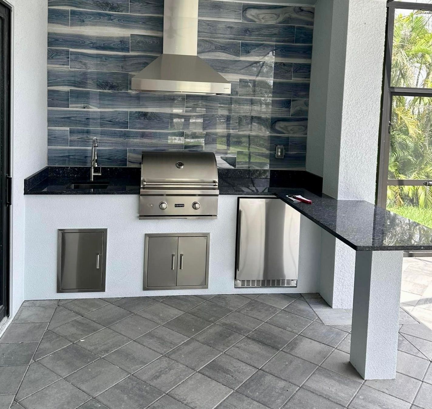 A kitchen with a grill and a hood above it.