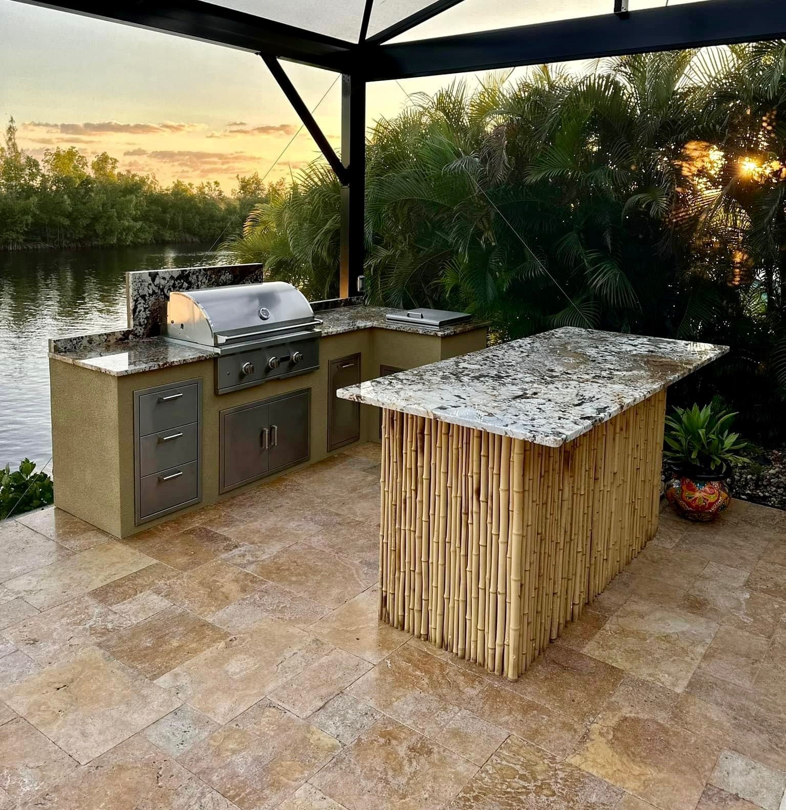 An outdoor kitchen with a bamboo island and a grill.