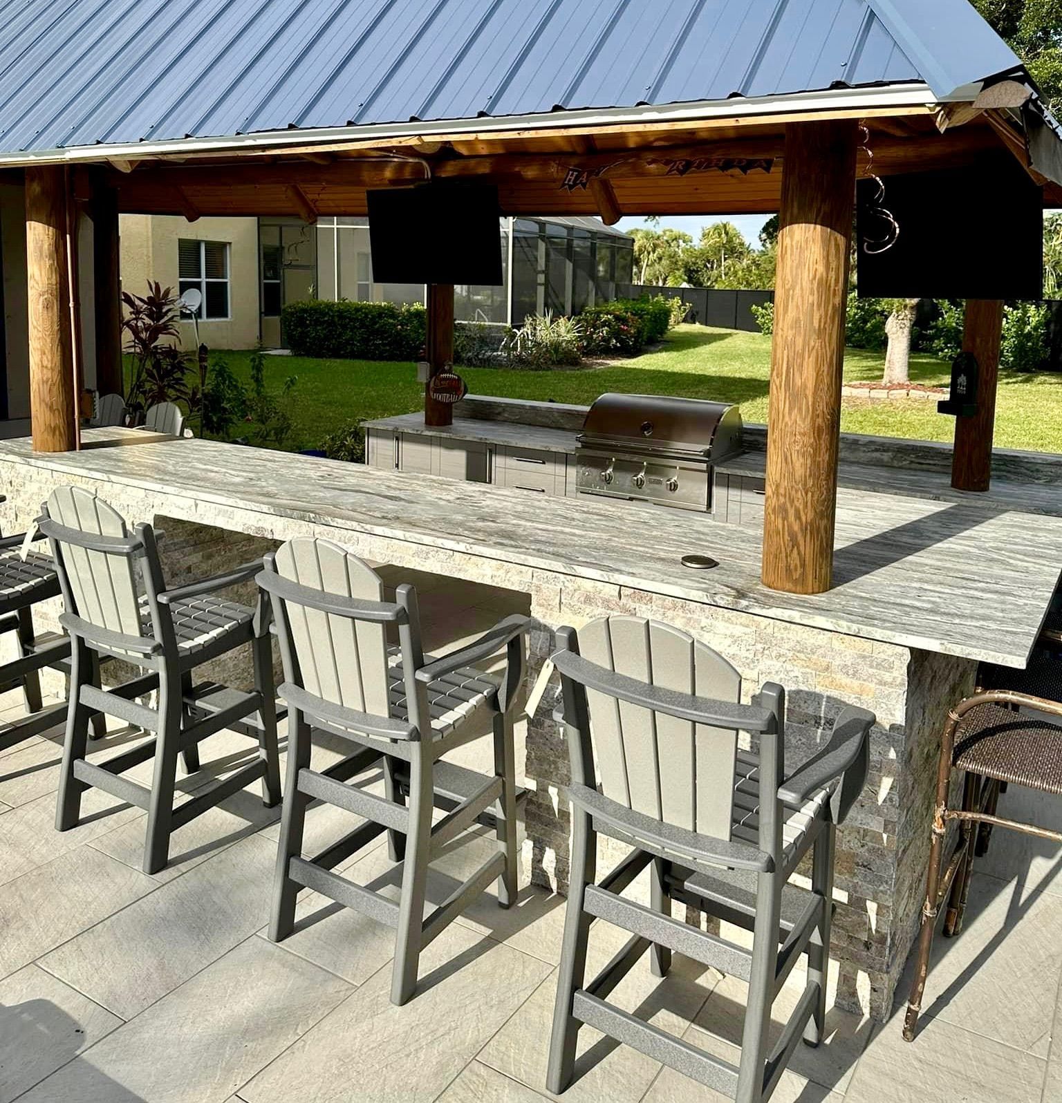 A patio with a table and chairs under a gazebo.