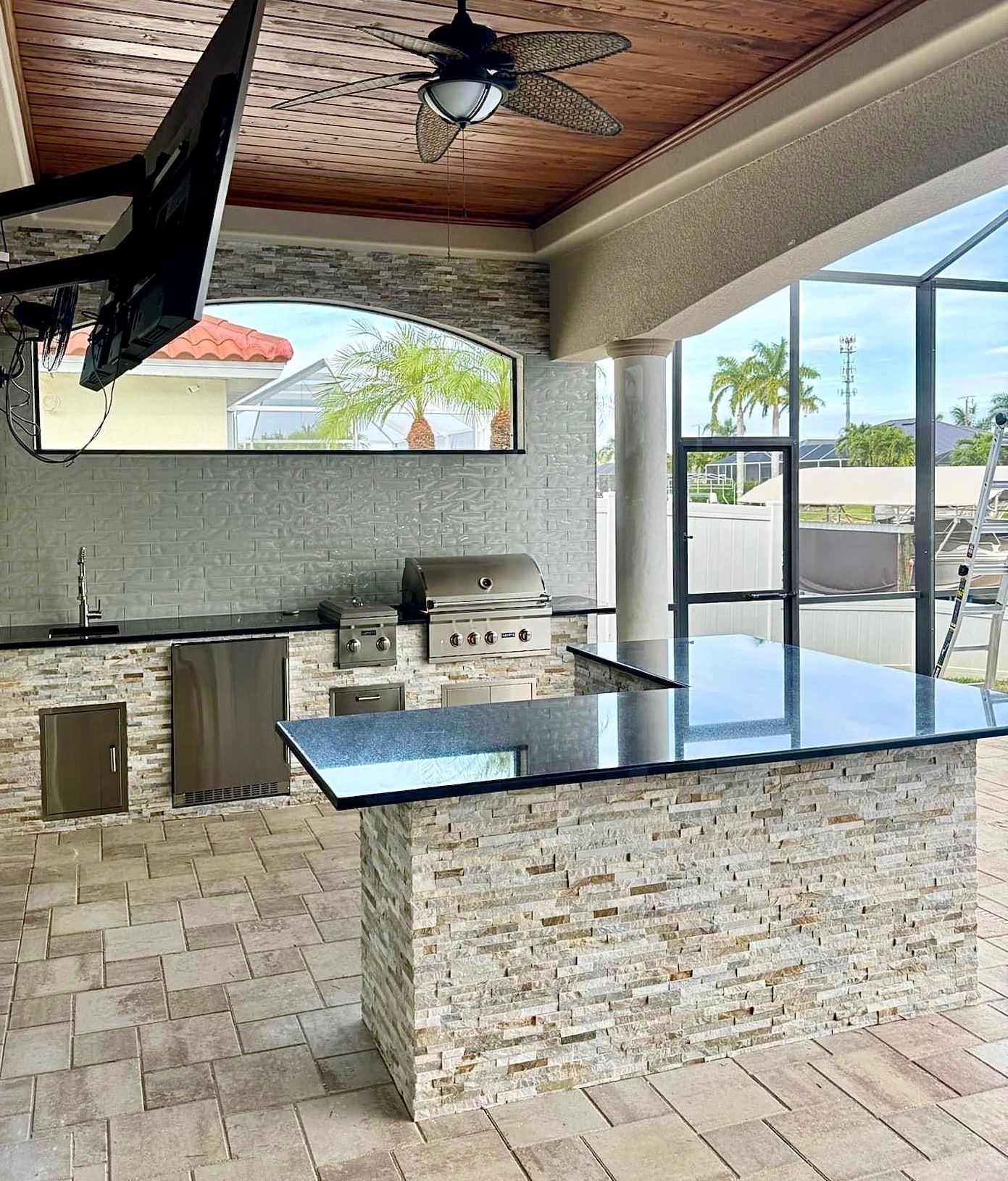 A kitchen with a large island and a ceiling fan.