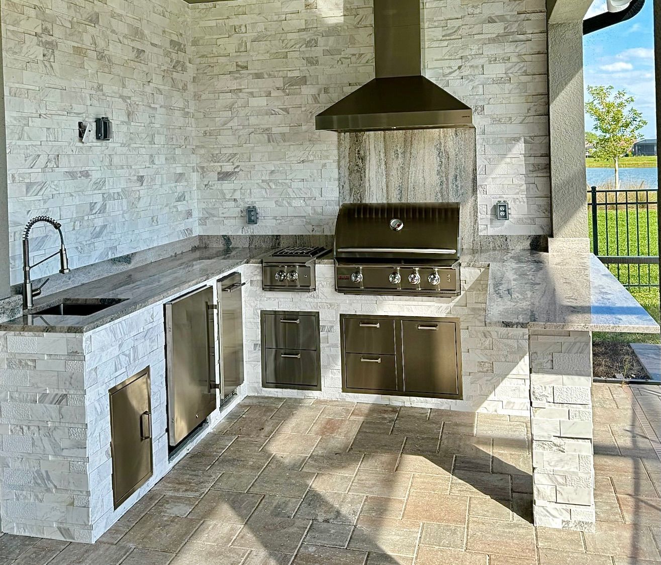 A kitchen with a stove, sink, and refrigerator.