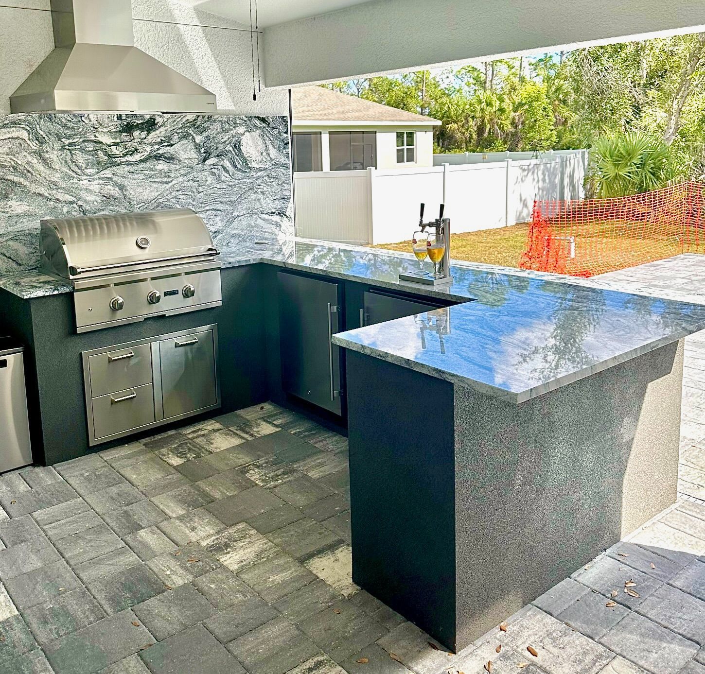 A kitchen with granite counter tops and a stainless steel grill.