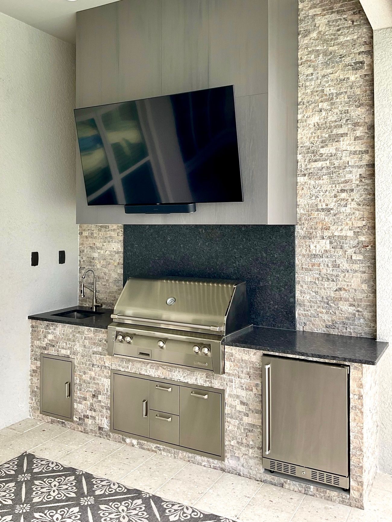 A kitchen with a grill and a flat screen tv on the wall.