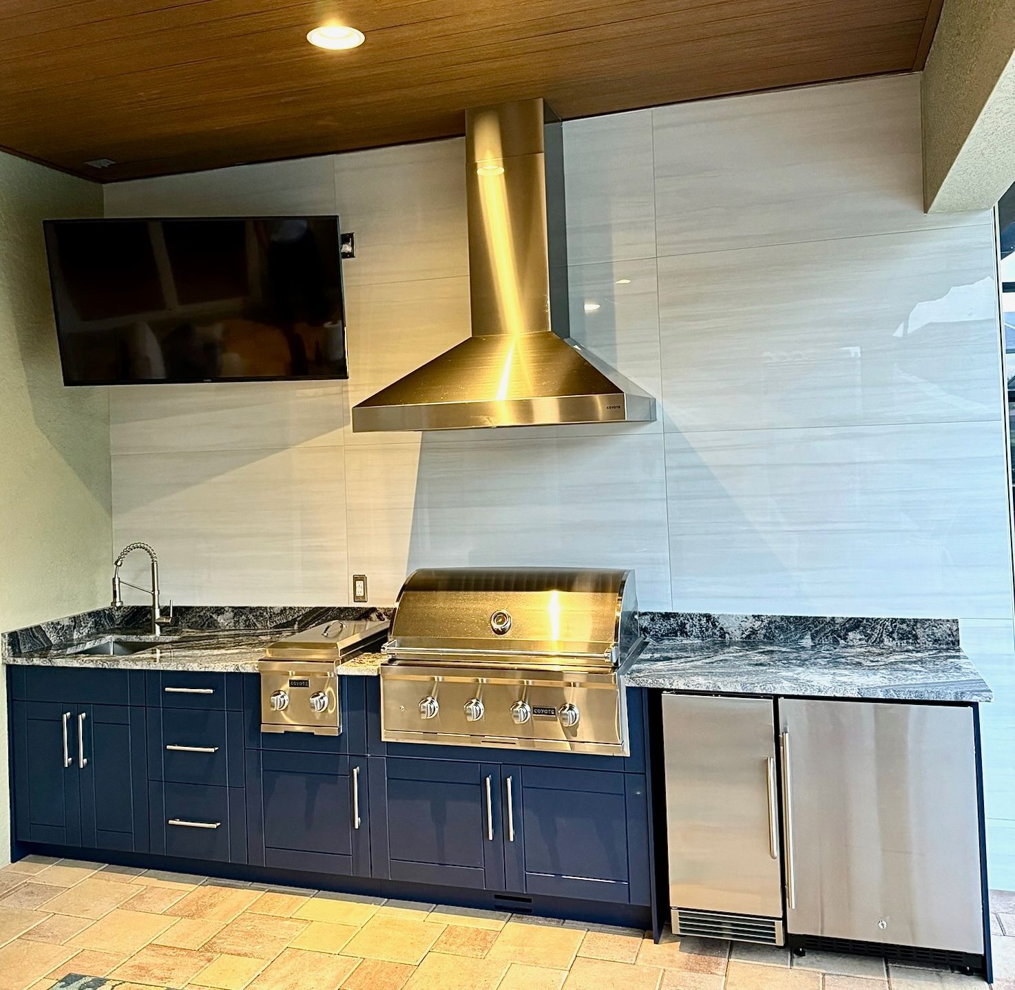 A kitchen with stainless steel appliances and blue cabinets.