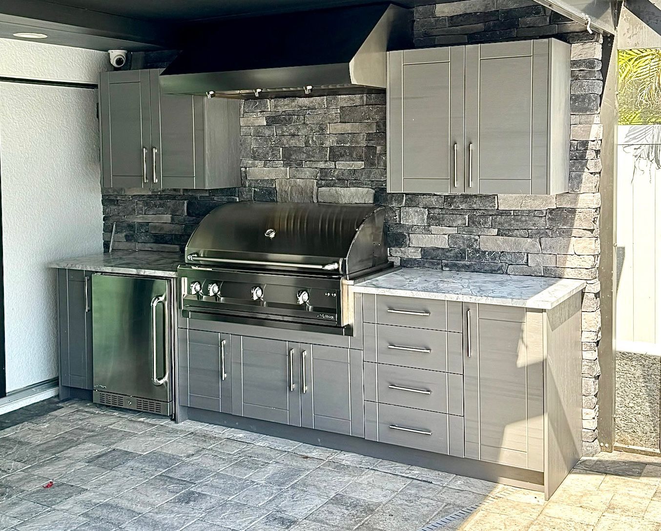 A kitchen with stainless steel cabinets and a grill.