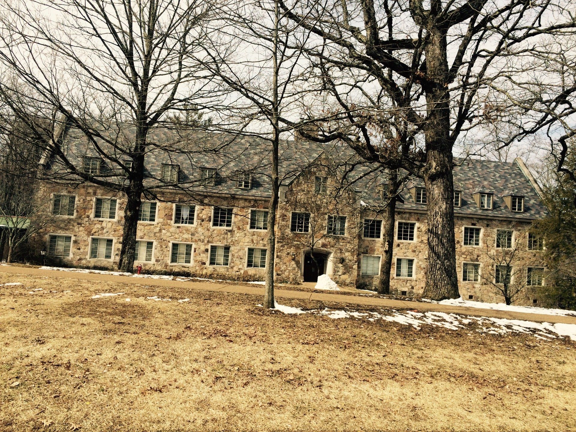 A large stone building with trees in front of it.