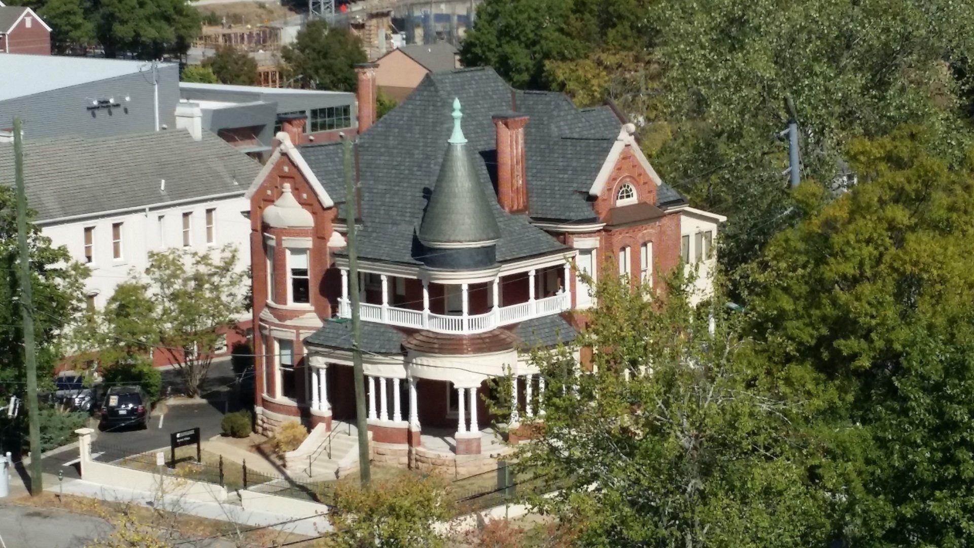 An aerial view of a large brick house with a gray roof