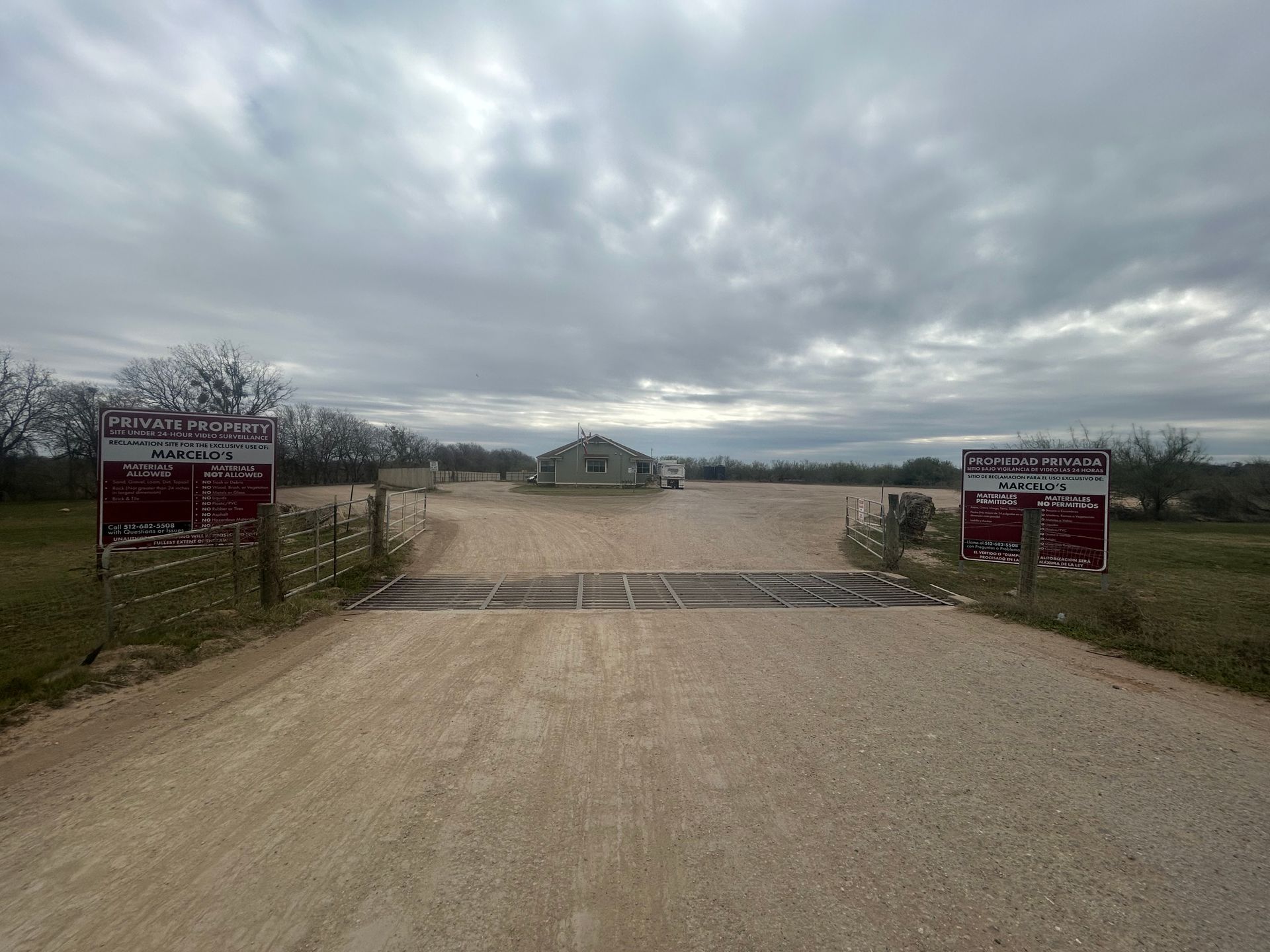 A dirt road with two signs on the side of it