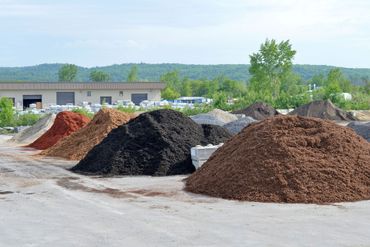 Various stone and cedar mulch piles separated into various type