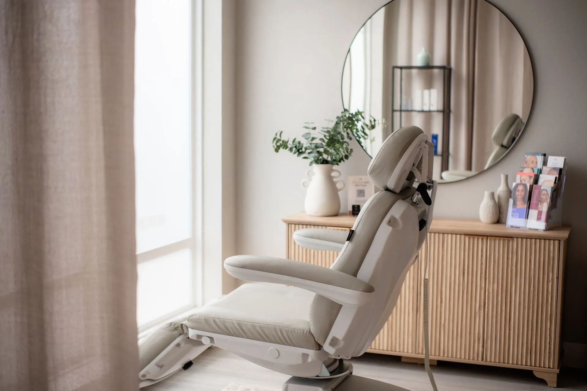 Modern beige massage chair in a bright living room beside a round mirror and wooden console