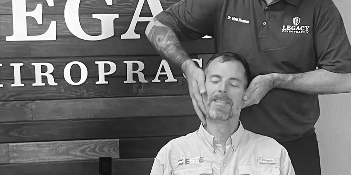 A chiropractor adjusting a patient's neck in a clinic.