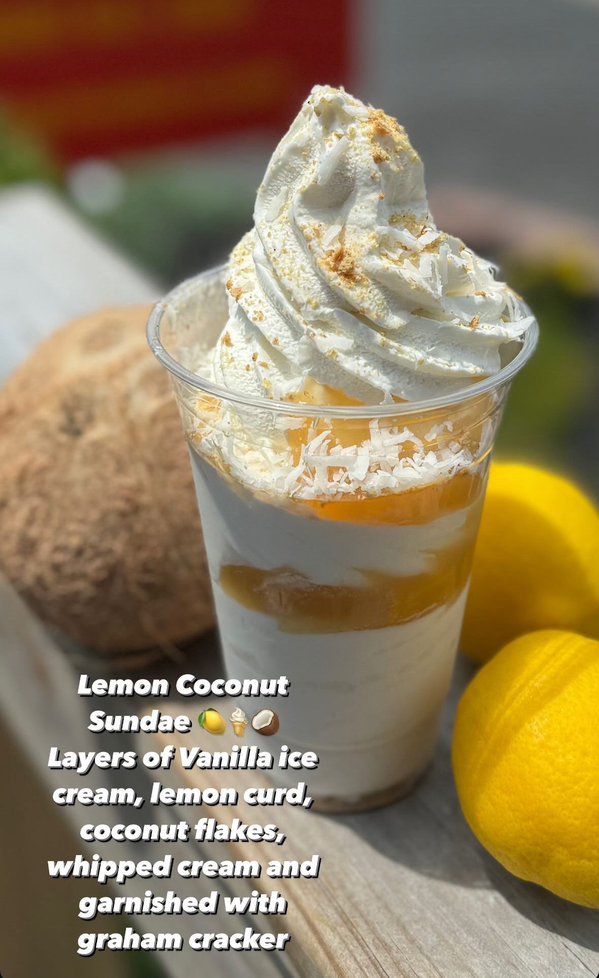 Lemon coconut sundae with vanilla ice cream, lemon curd, coconut flakes, whipped cream, and graham cracker crumbs