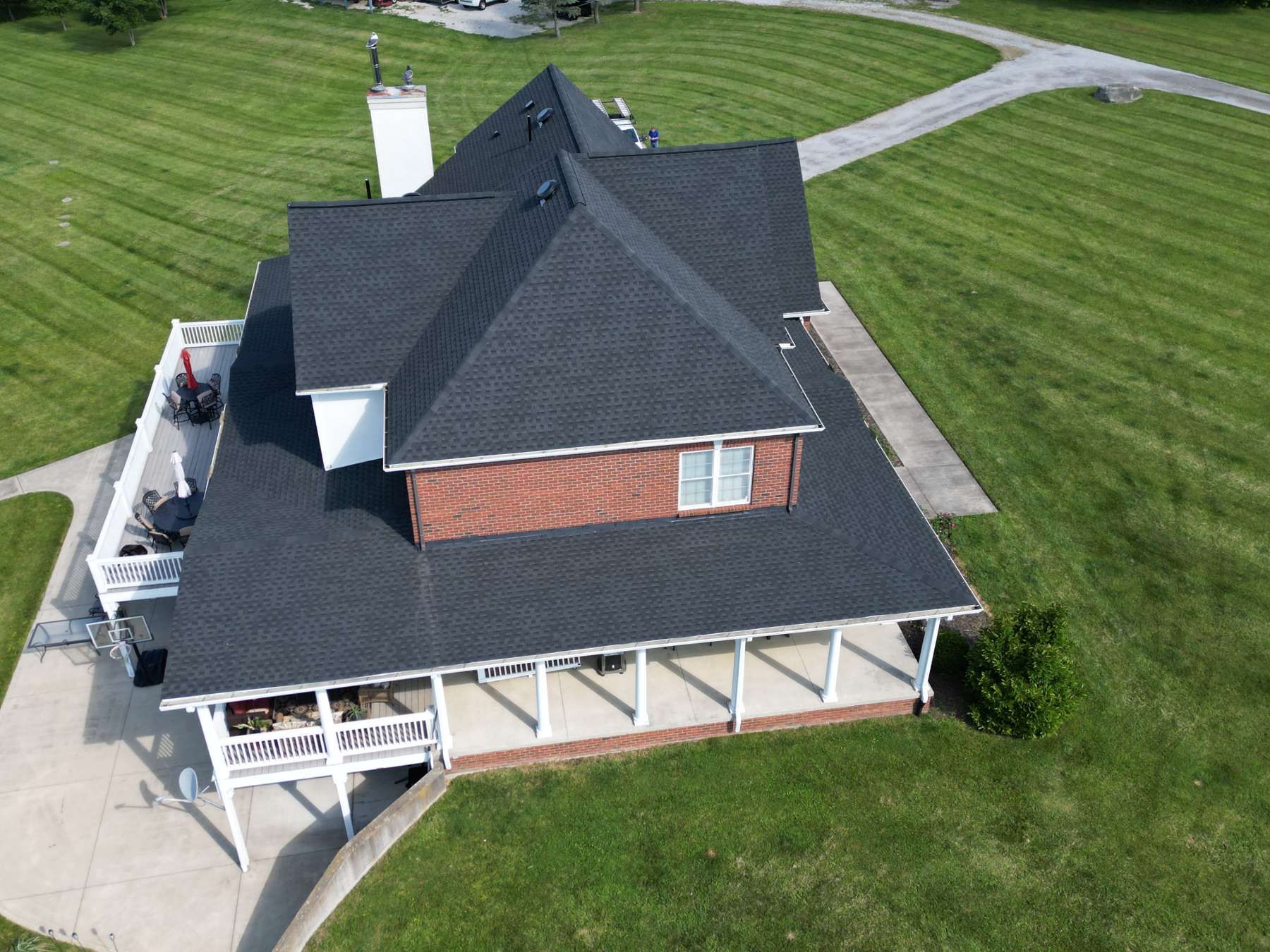 An aerial view of a large house with a black roof