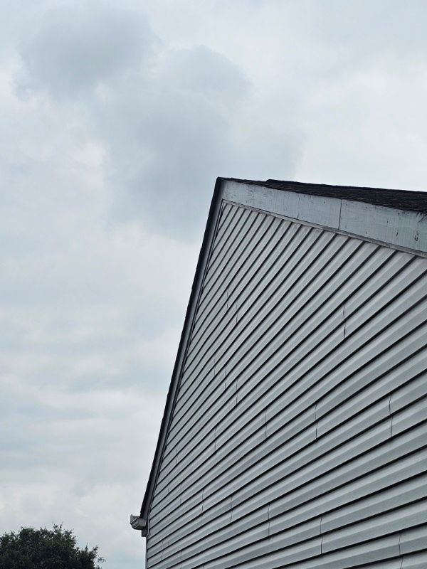 The roof of a building with a cloudy sky in the background.
