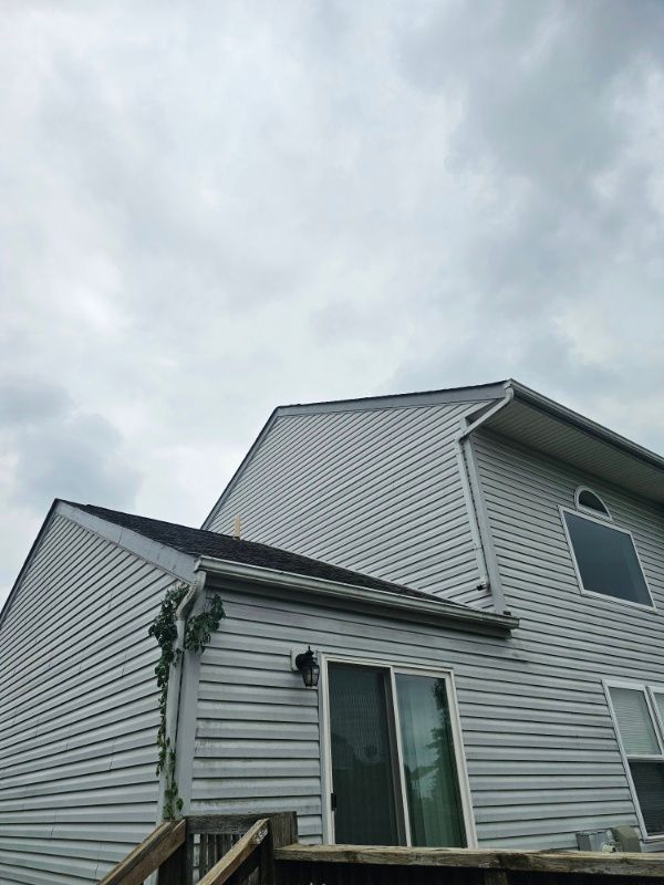 A white house with a black roof and a sliding glass door.