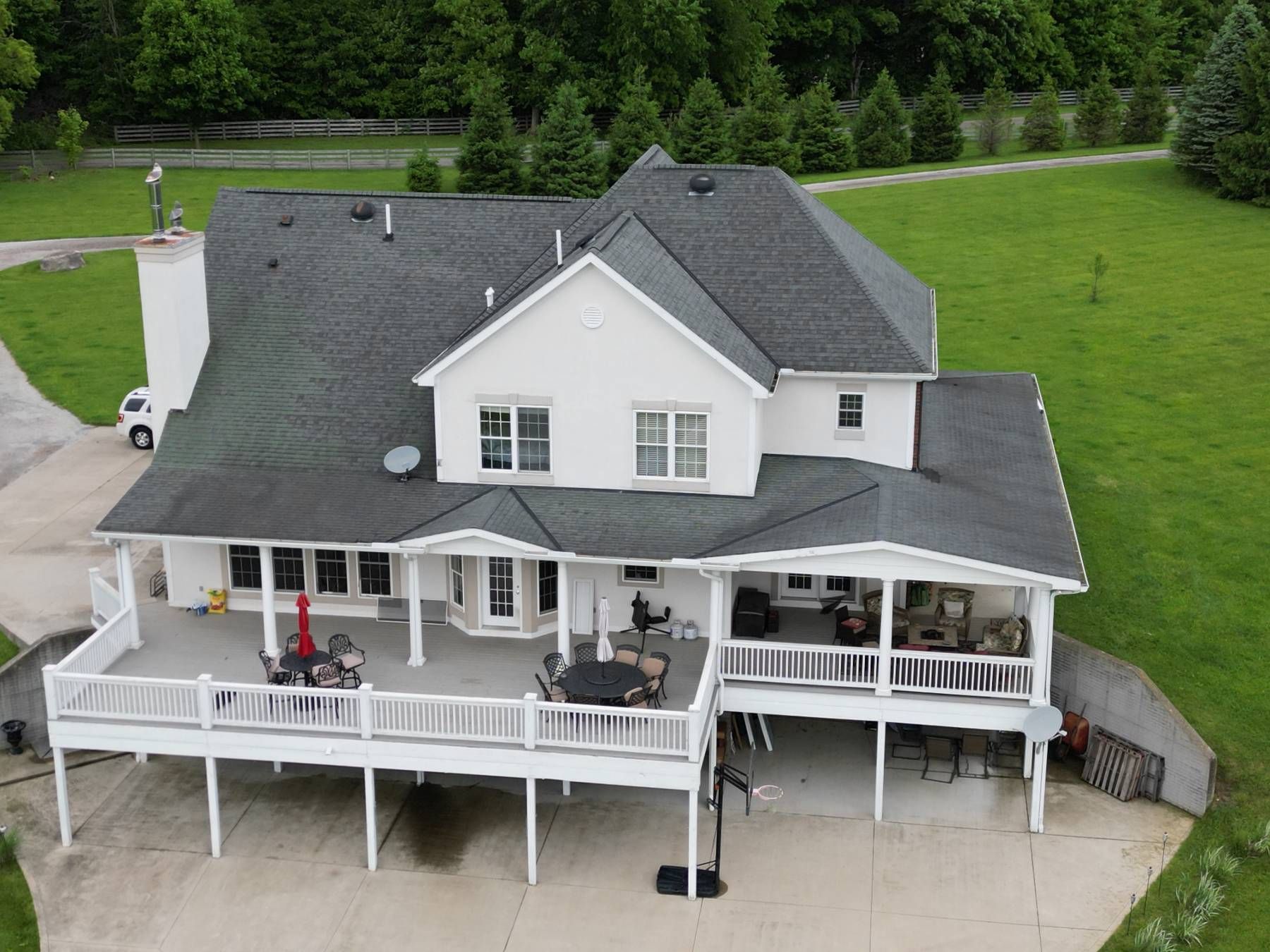 An aerial view of a large white house with a large deck