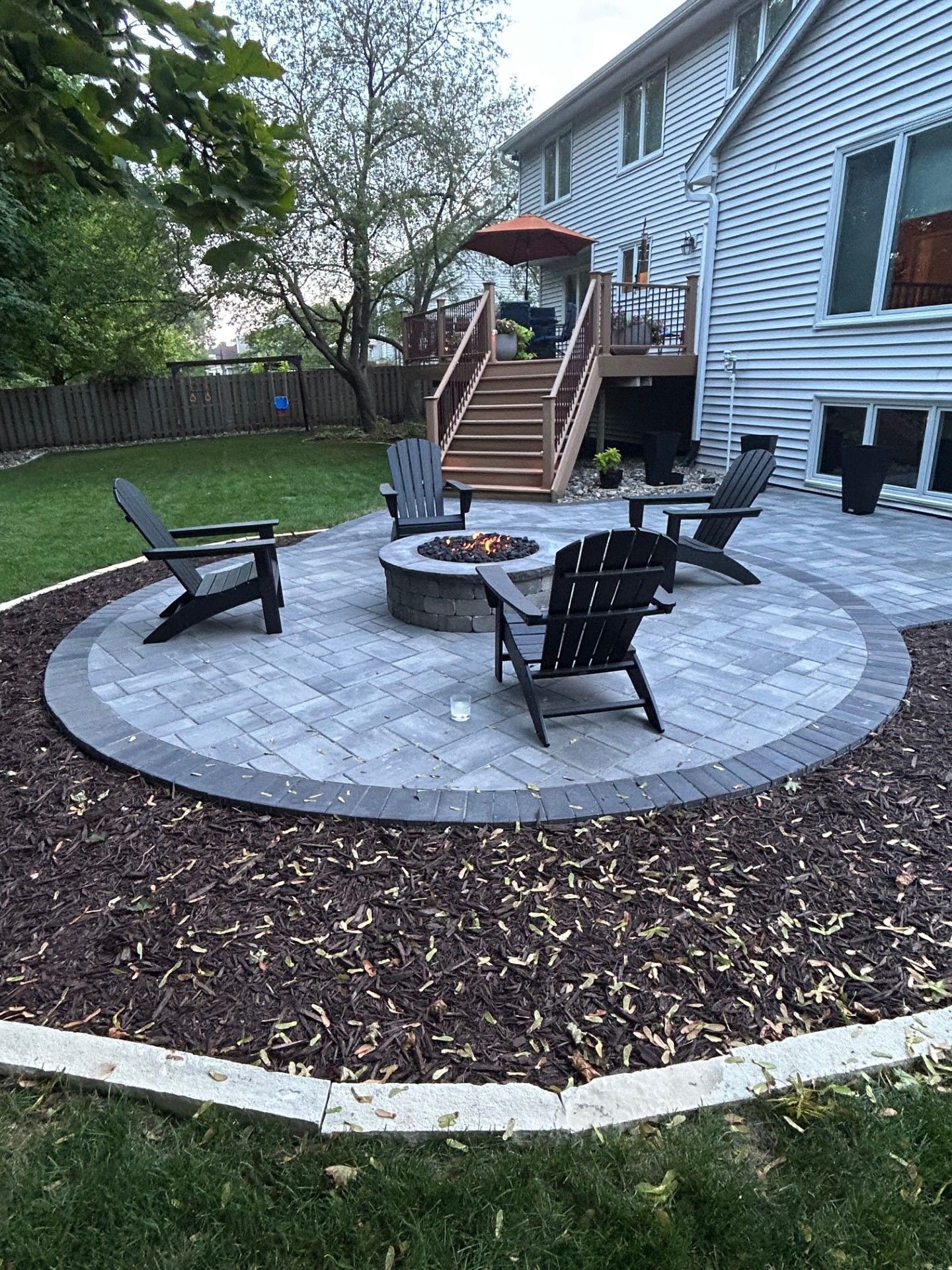 Paver patio with fire pit and chairs 