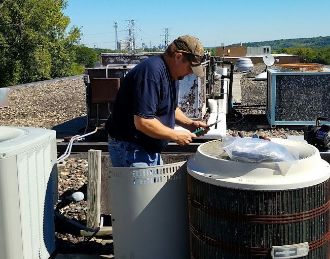 man installing heating & cooling system
