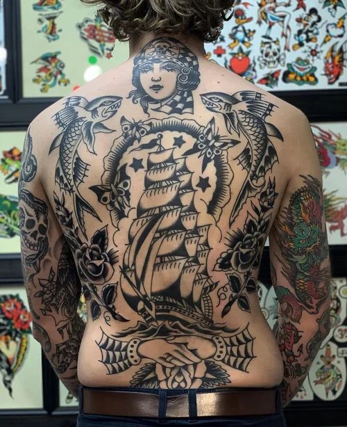 Back view of a person with a large black-and-gray tattoo spanning the entire back and arms