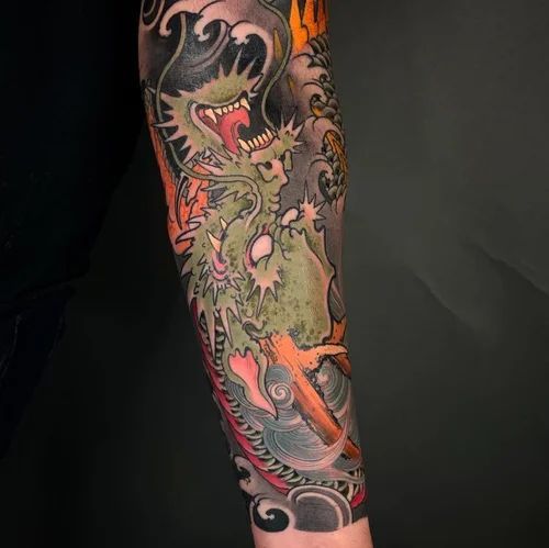 Forearm tattoo of a colorful dragon with black, orange, green, and pink details