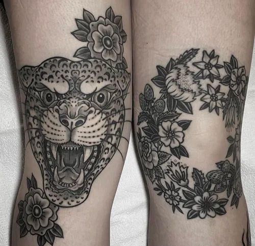 Close-up of two black-and-gray leg tattoos: a roaring leopard and a floral wreath