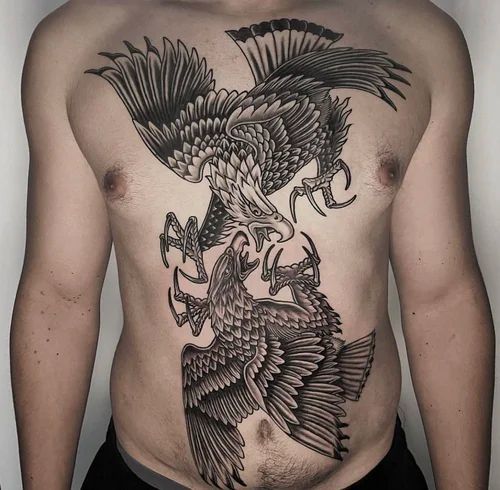 Torso with large black eagle tattoo design spanning chest and abdomen