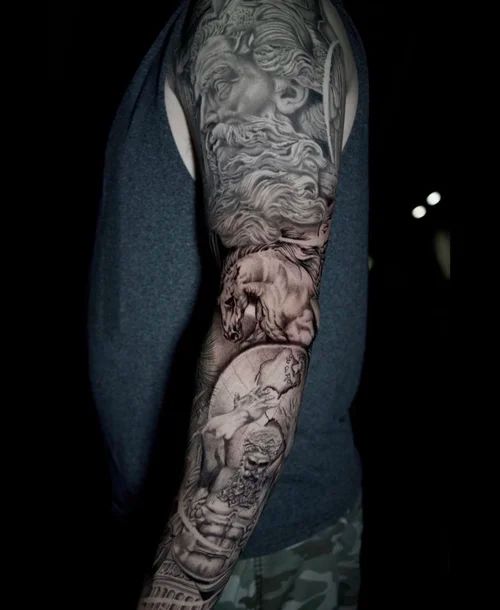 Arm tattoo sleeve with detailed black-and-gray portrait and animal designs on a person’s arm