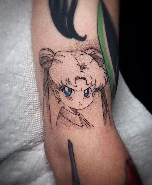 Anime-style face tattoo with blue eyes and dark hair on a forearm