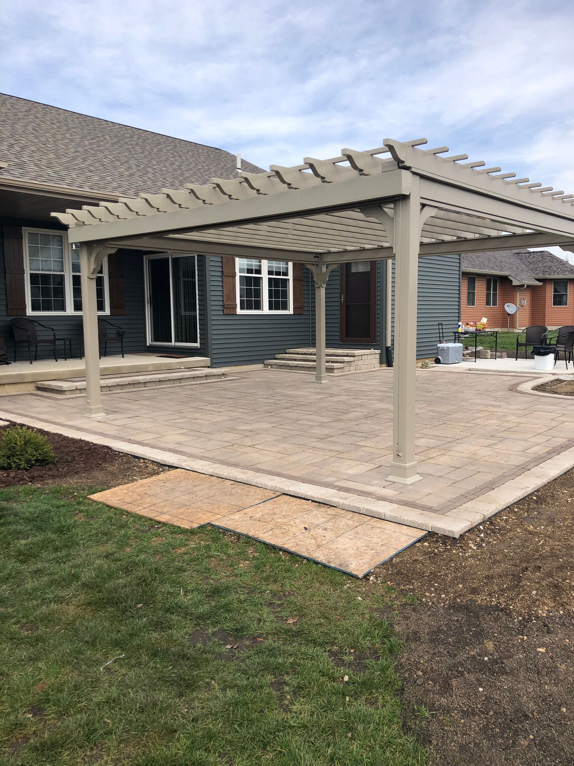 There is a pergola in the backyard of a house.