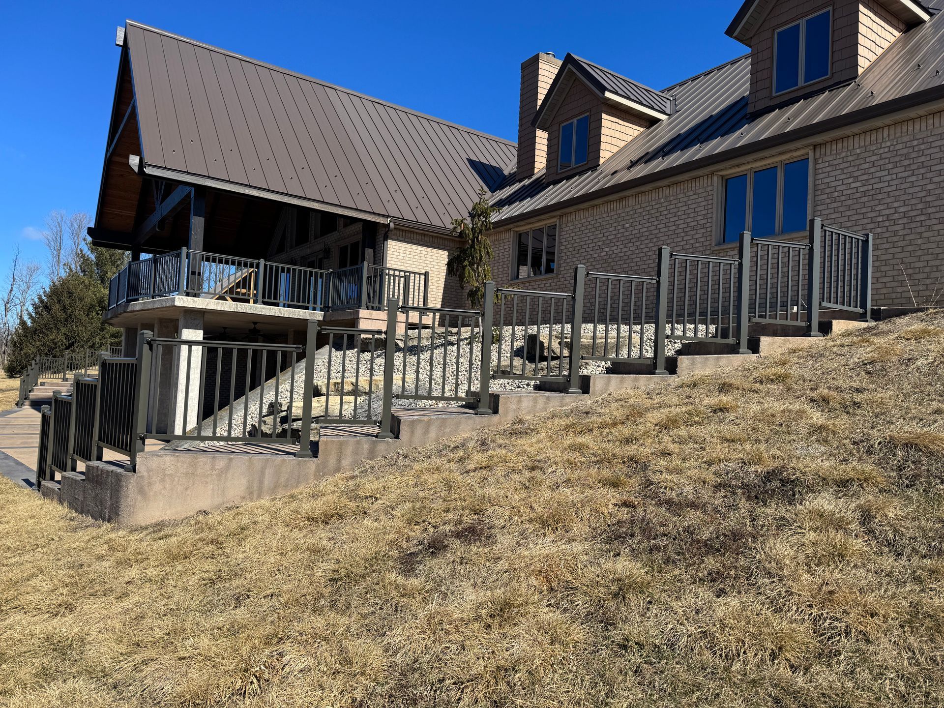 A large house is sitting on top of a grassy hill.