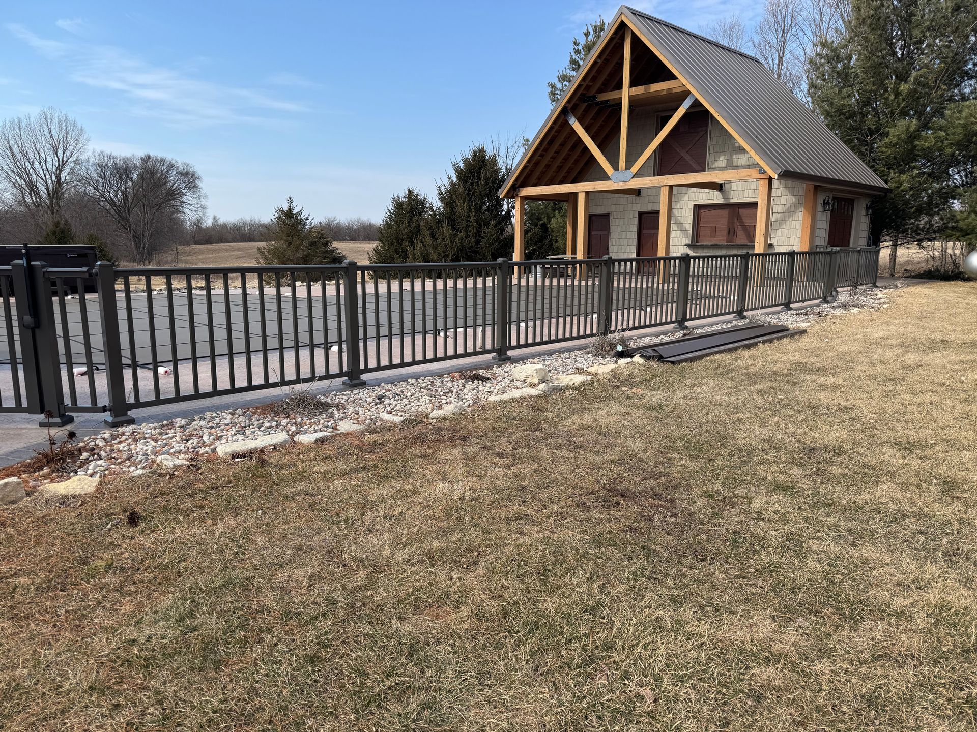 A house with a wooden roof and a fence in front of it.