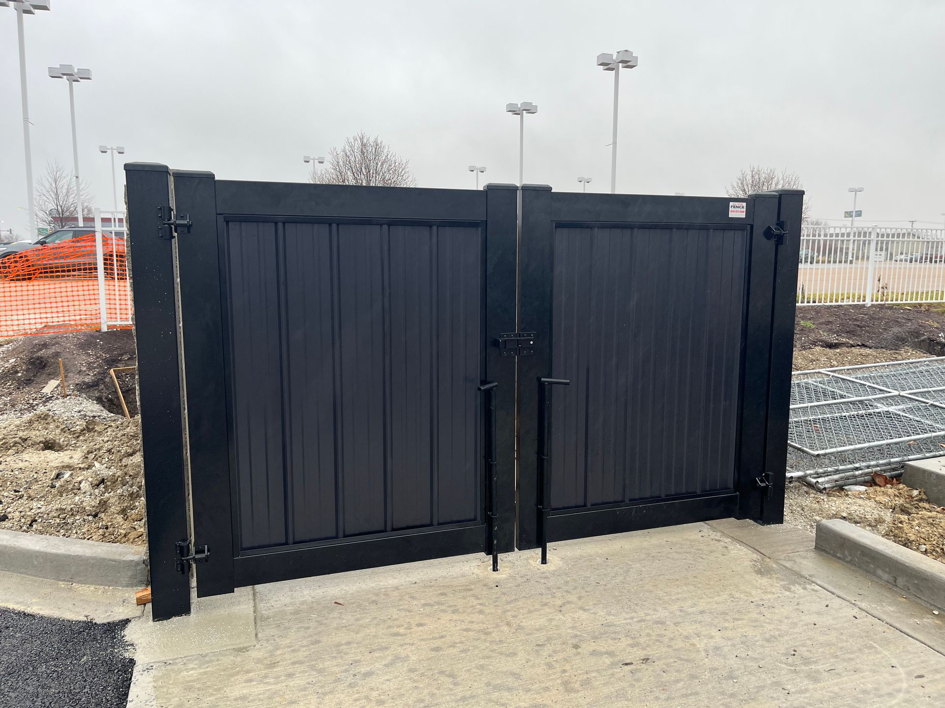 A black gate is sitting on top of a concrete sidewalk.