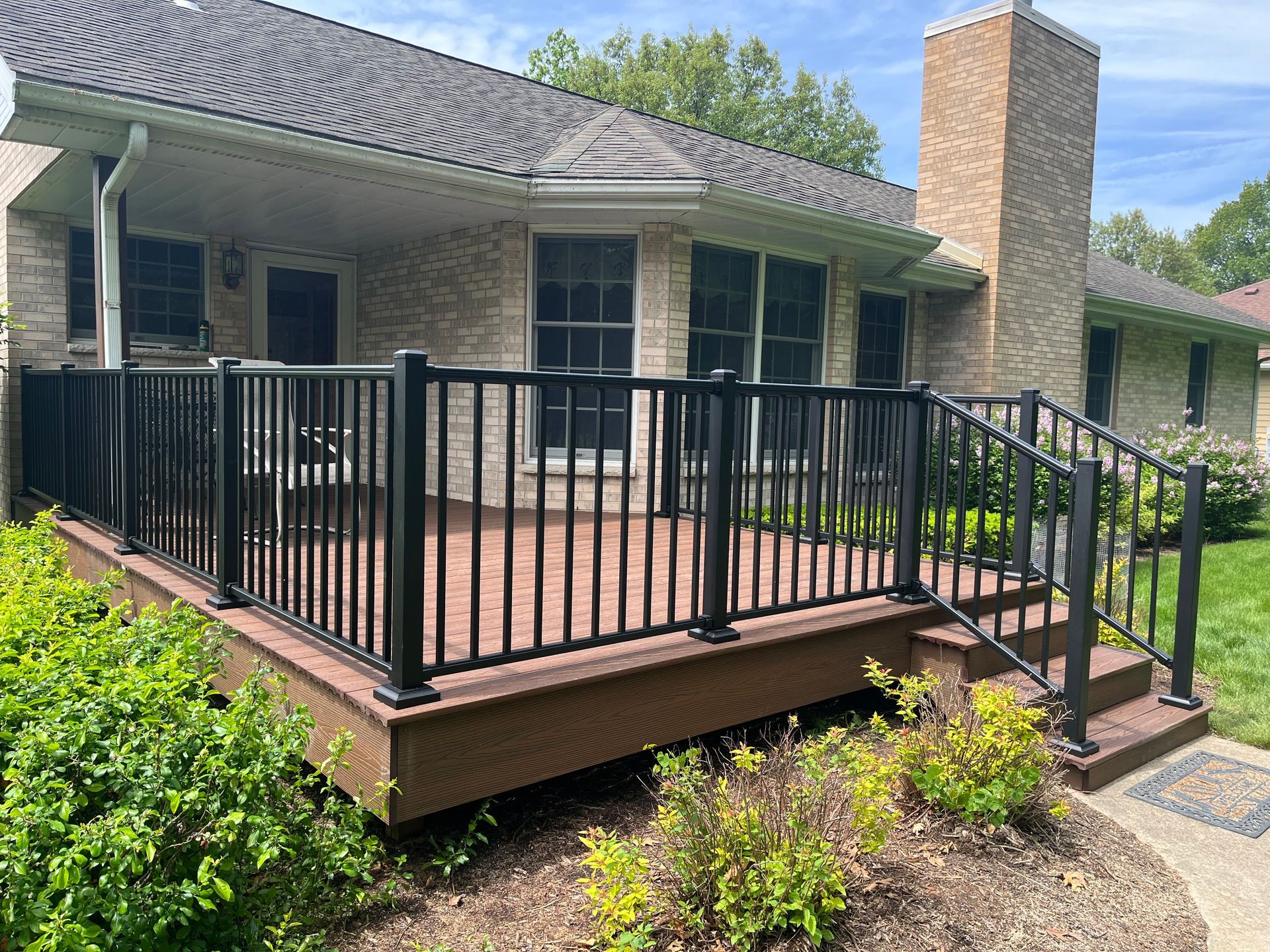 A house with a large deck and stairs in front of it.